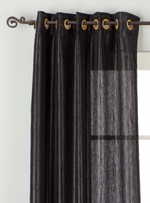 Black sari grommet top curtains hung at a window