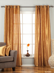 Gold sari grommet top curtains hung at a window