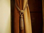 Golden sari curtain tiebacks holding a panel open