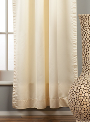 Cream sari rod pocket curtains hung at a window