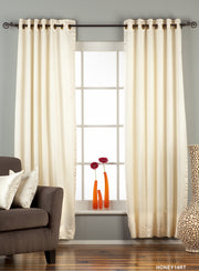 Cream sari grommet top curtains hung at a window