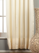Cream sari grommet top curtains hung at a window