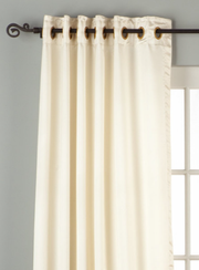 Cream sari grommet top curtains hung at a window