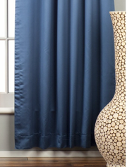 Blue sari grommet top curtains hung at a window