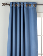 Blue sari grommet top curtains hung at a window