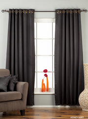 Black sari grommet top curtains hung at a window