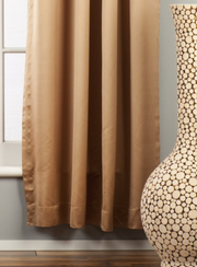 Taupe sari rod pocket curtains hung at a window