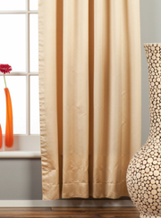 Golden sari grommet top curtains hung at a window
