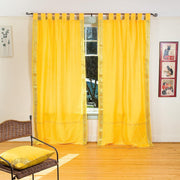 Yellow sari tab top curtains hung at a window