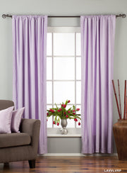 Lavender velvet rod pocket curtains hung at a window