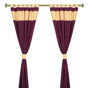 Maroon raw silk tab top curtains hung at a window