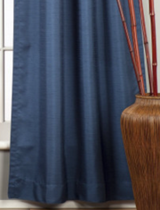 Blue raw silk rod pocket curtains hung at a window