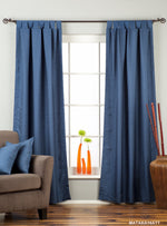 Blue raw silk tab top curtains hung at a window
