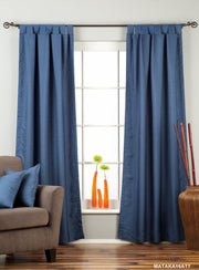 Blue raw silk tab top curtains hung at a window