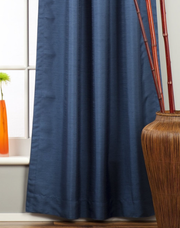 Blue raw silk tab top curtains hung at a window