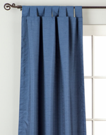 Blue raw silk tab top curtains hung at a window