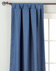 Blue raw silk tab top curtains hung at a window