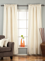 Cream raw silk rod pocket curtains hung at a window