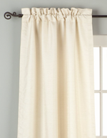 Cream raw silk rod pocket curtains hung at a window