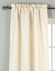 Cream raw silk rod pocket curtains hung at a window