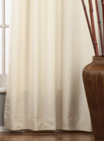 Cream raw silk ring top curtains hung at a window