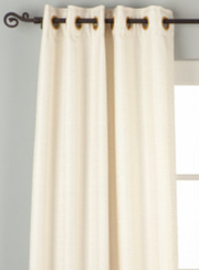 Cream raw silk ring top curtains hung at a window