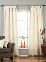 Cream raw silk tab top curtains hung at a window