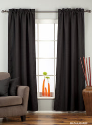 Black raw silk rod pocket curtains hung at a window