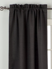 Black raw silk rod pocket curtains hung at a window