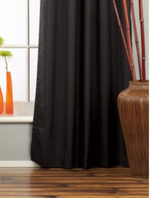 Black raw silk grommet top curtains hung at a window