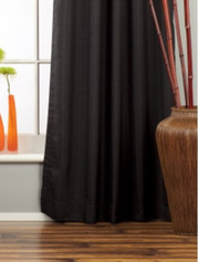 Black raw silk grommet top curtains hung at a window