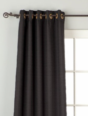 Black raw silk grommet top curtains hung at a window