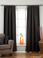 Black raw silk tab top curtains hung at a window