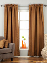 Brown raw silk rod pocket curtains hung at a window