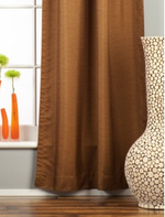 Brown raw silk rod pocket curtains hung at a window