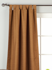 Brown raw silk tab top curtains hung at a window