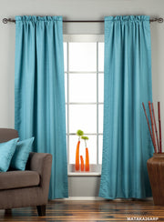 Turquoise raw silk rod pocket curtains hung at a window