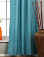 Turquoise raw silk rod pocket curtains hung at a window
