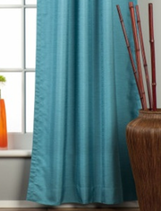 Turquoise raw silk rod pocket curtains hung at a window