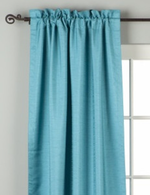 Turquoise raw silk rod pocket curtains hung at a window