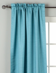 Turquoise raw silk rod pocket curtains hung at a window