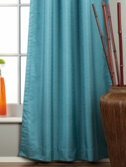 Turquoise raw silk tab top curtains hung at a window