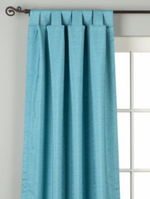 Turquoise raw silk tab top curtains hung at a window