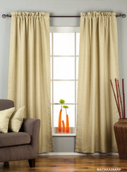 Olive green raw silk rod pocket curtains hung at a window