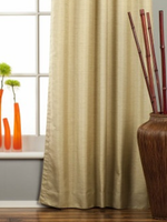 Olive green raw silk rod pocket curtains hung at a window