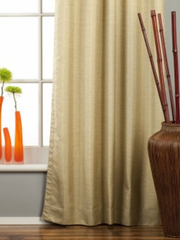 Olive green raw silk grommet top curtains hung at a window