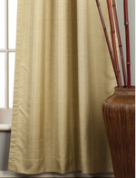 Olive green raw silk tab top curtains hung at a window
