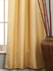 Golden rod raw silk rod pocket curtains hung at a window