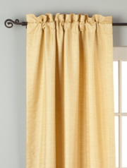 Golden rod raw silk rod pocket curtains hung at a window