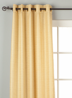 Golden raw silk grommet top curtains hung at a window